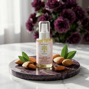 Huile d'Amande Douce BIO – Douceur Universelle almond oil bottle with almonds and green leaves on marble plate