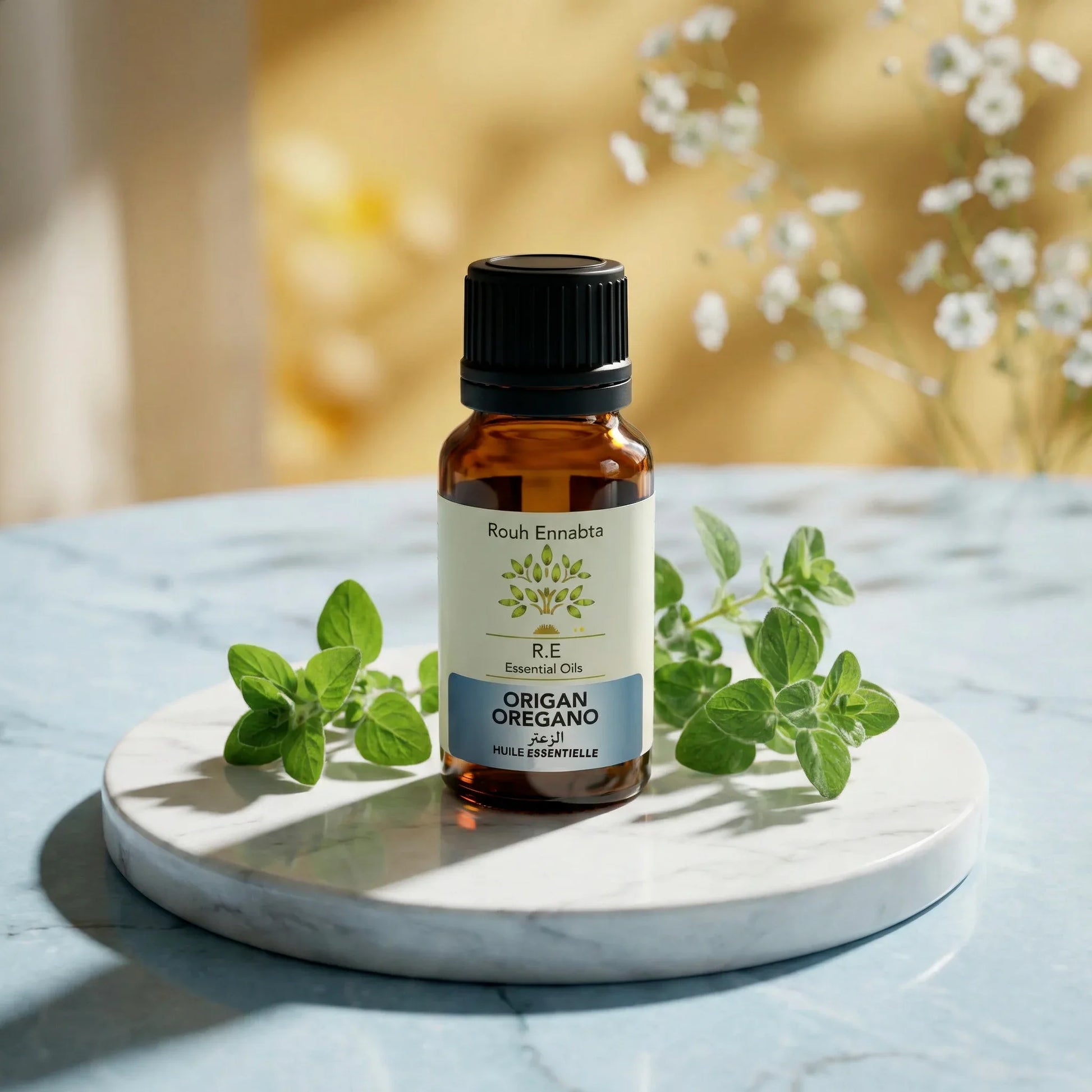Bottle of Huile Essentielle Origan Compact BIO | Anti-infectieuse & stimulante essential oil with oregano leaves on marble plate